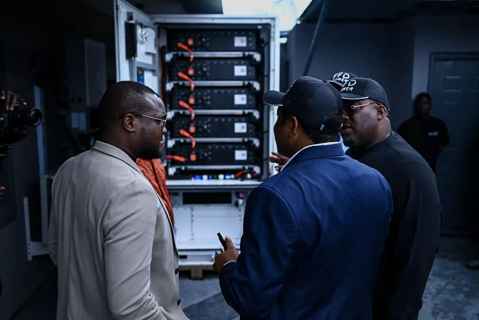 Commissioning a cabinet BESS for a headquarters microgrid in Nigeria, with the battery rack visible inside the open enclosure